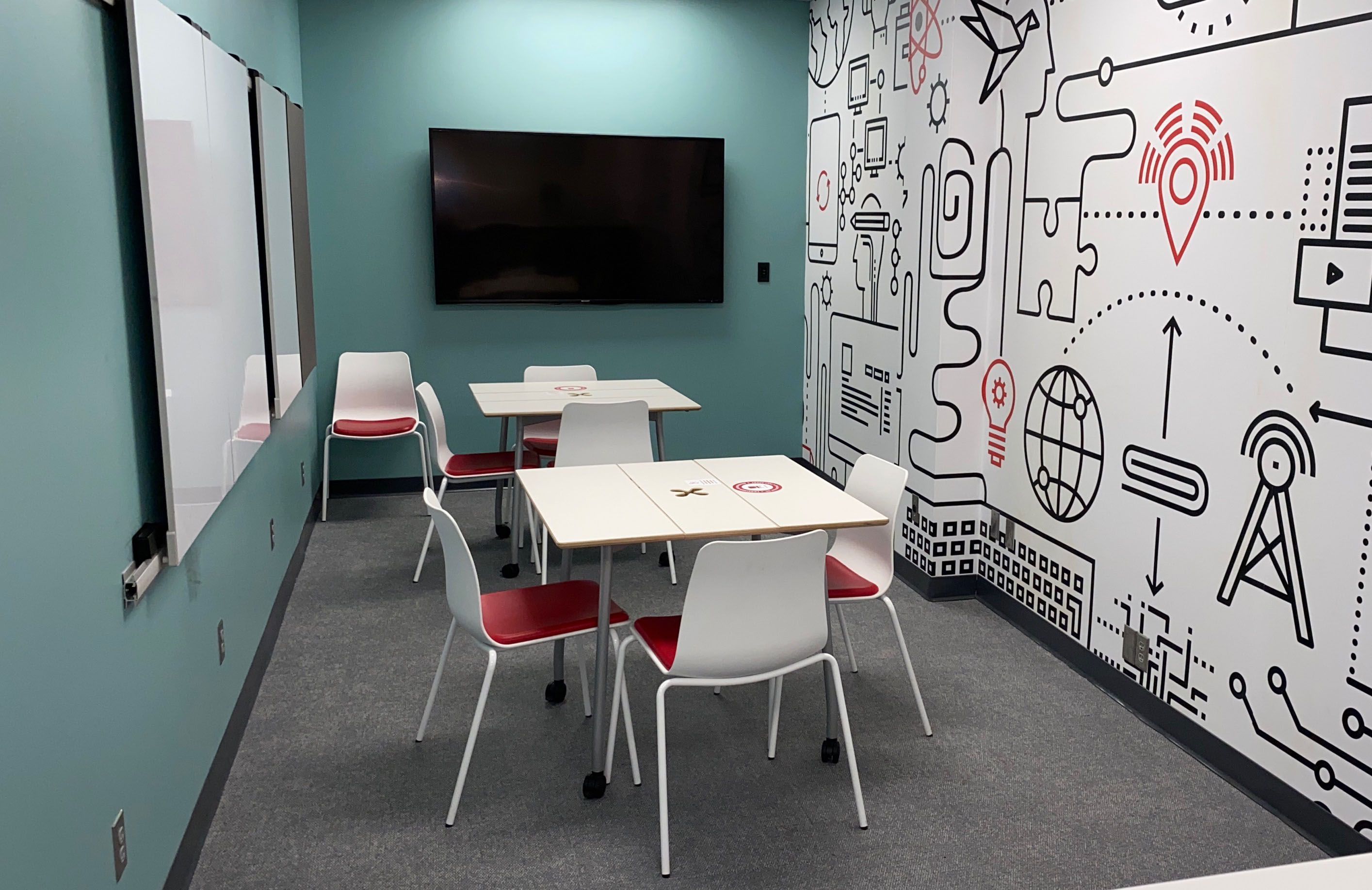 Tables and chairs with whiteboards on the walls