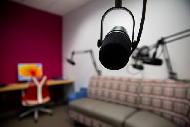 A microphone in front of couch seating and an iMac computer.